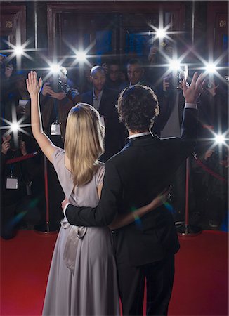 desenrollar la alfombra roja - Rear view of well dressed celebrity couple waving to paparazzi on red carpet Foto de stock - Sin royalties Premium, Código: 6113-07160047