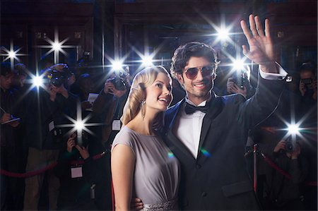 Well dressed celebrity couple waving to paparazzi at red carpet event Foto de stock - Sin royalties Premium, Código: 6113-07160046