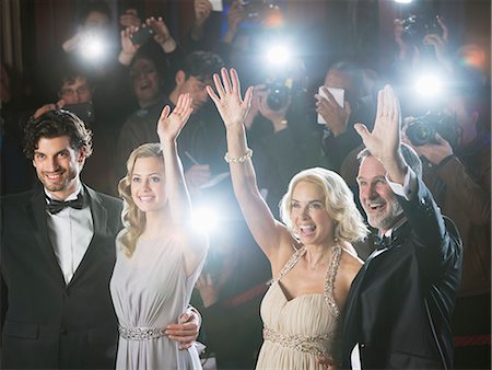 red carpet camera flashes - Well dressed celebrity couples waving to paparazzi at red carpet event Stock Photo - Premium Royalty-Free, Code: 6113-07160078