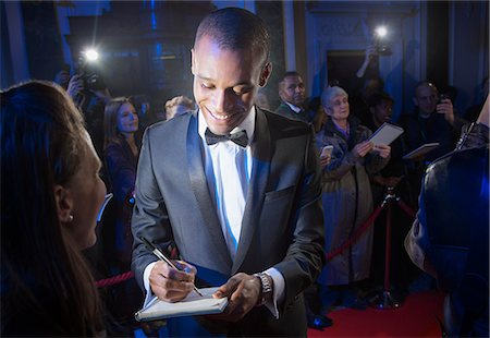 personas prominentes - Well dressed celebrity signing autograph on red carpet Foto de stock - Sin royalties Premium, Código: 6113-07160085
