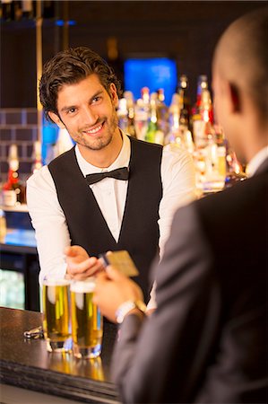 people give money to someone - Well dressed bartender taking credit card from customer in luxury bar Stock Photo - Premium Royalty-Free, Code: 6113-07160014