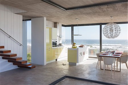 simsearch:6113-07159868,k - Modern kitchen and dining room overlooking ocean Foto de stock - Sin royalties Premium, Código: 6113-07160167