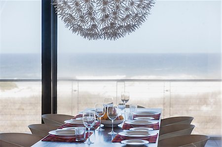 simsearch:6113-07159424,k - Set table in modern dining room overlooking ocean Foto de stock - Sin royalties Premium, Código: 6113-07160165