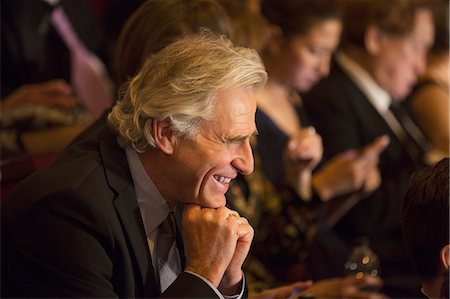 photo of theatre audience laughing - Close up of man laughing in theater audience Stock Photo - Premium Royalty-Free, Code: 6113-07160109