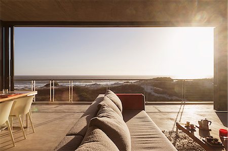 simsearch:851-02962748,k - Modern living room overlooking ocean Photographie de stock - Premium Libres de Droits, Code: 6113-07160136