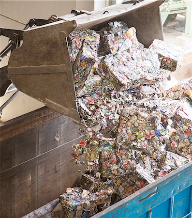 Bucket dumping recycled bundles into bin Foto de stock - Sin royalties Premium, Código: 6113-07160266