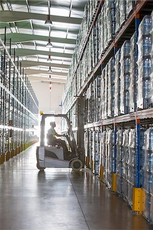 Worker operating forklift in warehouse Photographie de stock - Premium Libres de Droits, Code: 6113-07160274