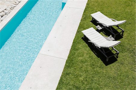 Lounge chairs on grass along lap pool Photographie de stock - Premium Libres de Droits, Code: 6113-07160205
