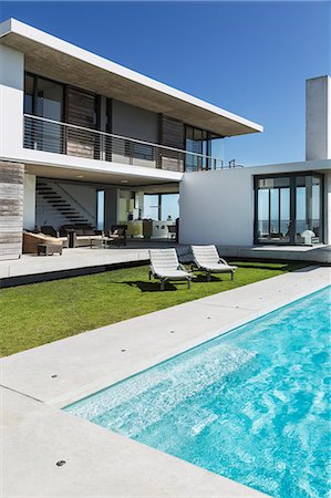 patio lounge chair - Lounge chairs and swimming pool outside modern house Photographie de stock - Premium Libres de Droits, Code: 6113-07160213