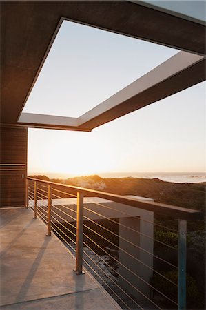 Balcony of modern house overlooking ocean at sunset Foto de stock - Sin royalties Premium, Código: 6113-07160214