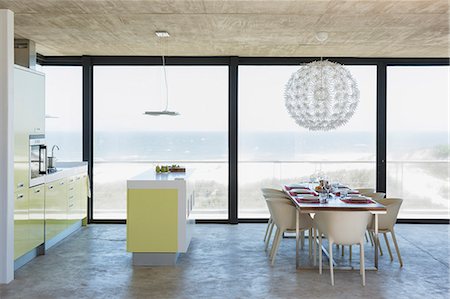 simsearch:6113-07589653,k - Modern dining room and kitchen overlooking ocean Photographie de stock - Premium Libres de Droits, Code: 6113-07160223
