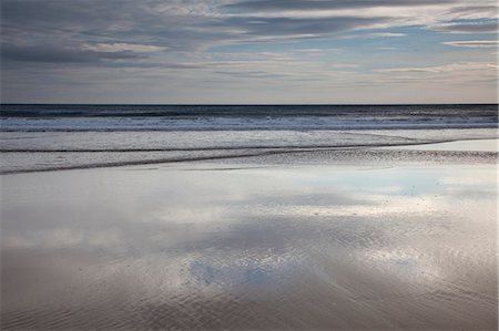 simsearch:6113-08947383,k - Sun reflecting on beach at low tide Photographie de stock - Premium Libres de Droits, Code: 6113-07160369