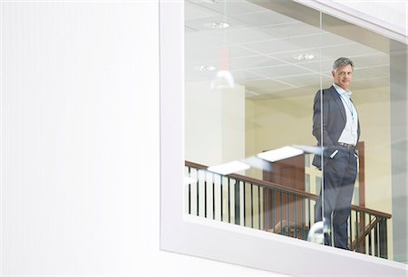 simsearch:6113-07589271,k - Businessman looking out glass window Stock Photo - Premium Royalty-Free, Code: 6113-07160303