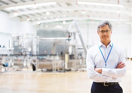 factory - Businessman smiling in factory Stock Photo - Premium Royalty-Free, Code: 6113-07160339