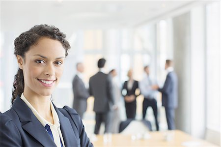 simsearch:6113-06908856,k - Businesswoman smiling in meeting Foto de stock - Royalty Free Premium, Número: 6113-07160461