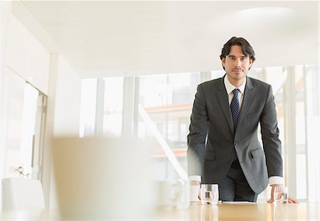 successful men at office - Businessman standing at conference table Stock Photo - Premium Royalty-Free, Code: 6113-07160483