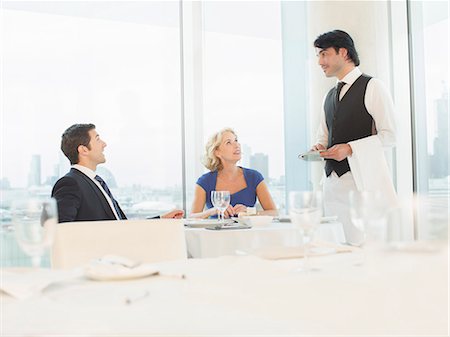 Business people talking to waiter in restaurant Stock Photo - Premium Royalty-Free, Code: 6113-07160545