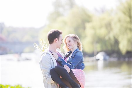 romance and spring - Man carrying girlfriend along river Stock Photo - Premium Royalty-Free, Code: 6113-07160565
