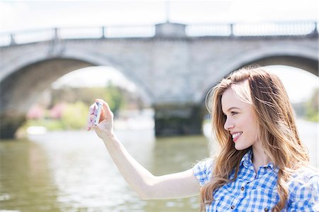 digitalkamera - Woman taking self-portrait along river Photographie de stock - Premium Libres de Droits, Code: 6113-07160585