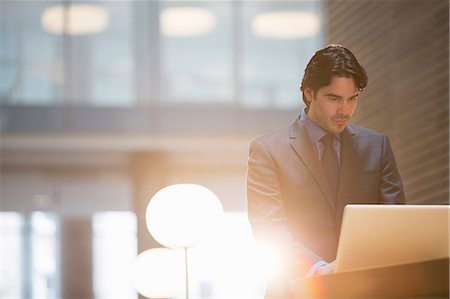 standing on a table - Businessman using laptop in office Stock Photo - Premium Royalty-Free, Code: 6113-07160530