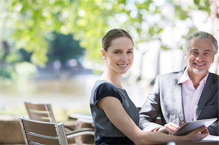 Business people smiling at sidewalk cafe Stock Photo - Premium Royalty-Free, Code: 6113-07160655