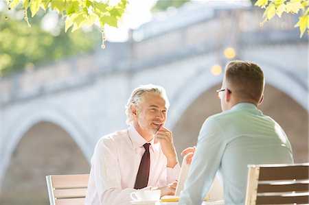 discussion - Businessmen talking at sidewalk cafe Photographie de stock - Premium Libres de Droits, Code: 6113-07160664