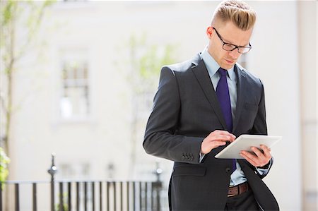 simsearch:6113-07543525,k - Businessman using digital tablet on city street Stock Photo - Premium Royalty-Free, Code: 6113-07160698