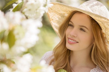 Woman admiring flowers outdoors Photographie de stock - Premium Libres de Droits, Code: 6113-07160628