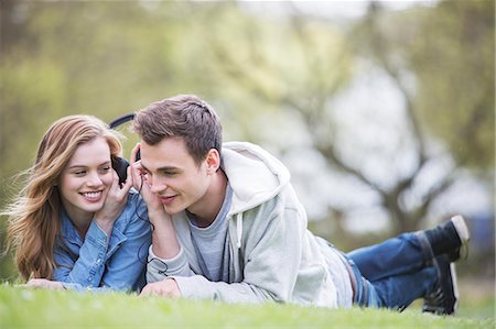 earphone sharing - Couple listening to headphones in park Stock Photo - Premium Royalty-Free, Code: 6113-07160634