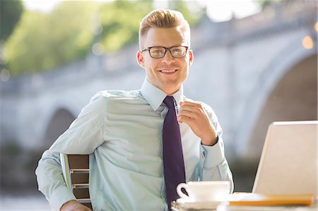 Businessman smiling at sidewalk cafe Stock Photo - Premium Royalty-Free, Code: 6113-07160705