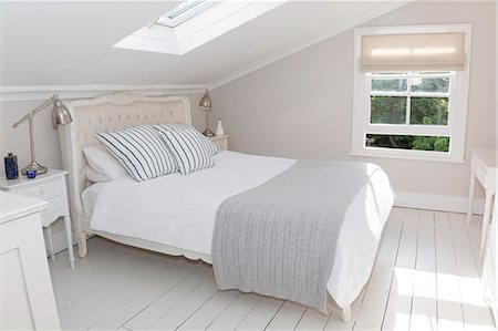 encalado - Bed in whitewashed attic bedroom Foto de stock - Sin royalties Premium, Código: 6113-07160717
