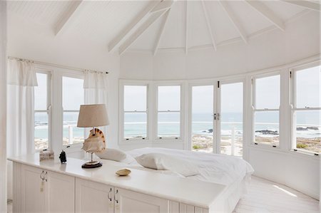 simsearch:6113-07159413,k - White bedroom overlooking ocean Stock Photo - Premium Royalty-Free, Code: 6113-07160847