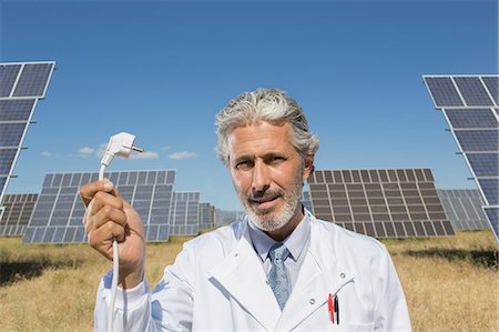 solar cell green - Scientist holding plug to solar panels Stock Photo - Premium Royalty-Free, Code: 6113-07160878