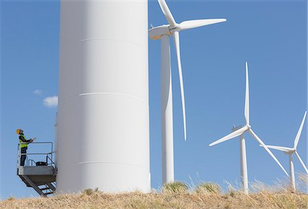 electrical work - Worker examining wind turbine in rural landscape Photographie de stock - Premium Libres de Droits, Code: 6113-07160893