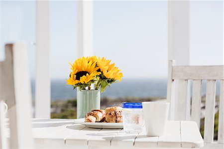 Sunflowers and croissants on patio table Foto de stock - Sin royalties Premium, Código: 6113-07160811