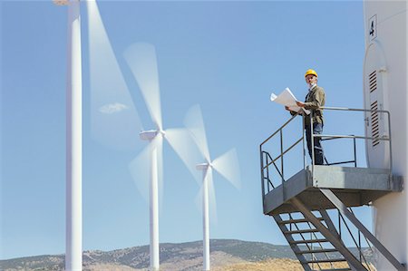 Worker standing on wind turbine in rural landscape Foto de stock - Sin royalties Premium, Código: 6113-07160942