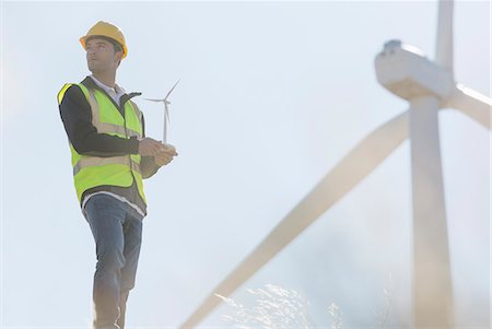 Worker by wind turbines in rural landscape Fotografie stock - Premium Royalty-Free, Codice: 6113-07160963