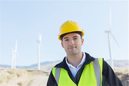 Worker standing by wind turbines in rural landscape Stock Photo - Premium Royalty-Free, Code: 6113-07160904