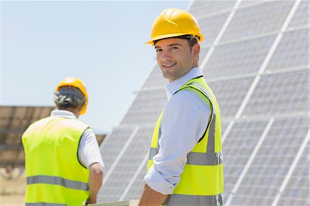 environmental protection - Workers walking by solar panels in rural landscape Stock Photo - Premium Royalty-Free, Code: 6113-07160912