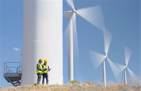 Workers talking by wind turbines in rural landscape Fotografie stock - Premium Royalty-Free, Codice: 6113-07160928