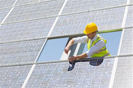 panneau solaire - Worker examining solar panel in rural landscape Photographie de stock - Premium Libres de Droits, Code: 6113-07160936