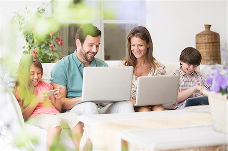 son and dad cell phone - Family with laptops, digital tablet and cell phone on patio sofa Stock Photo - Premium Royalty-Free, Code: 6113-07242053