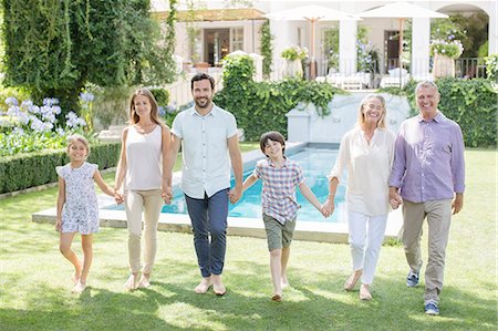 Multi-generation family holding hands and walking in backyard Foto de stock - Sin royalties Premium, Código: 6113-07242063