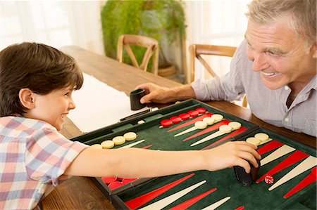 Grandfather and grandson playing backgammon Stock Photo - Premium Royalty-Free, Code: 6113-07242077