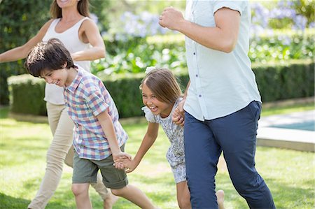 simsearch:649-05801821,k - Family holding hands and running in backyard Photographie de stock - Premium Libres de Droits, Code: 6113-07242080