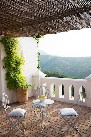 Table and chairs on balcony overlooking mountain Foto de stock - Sin royalties Premium, Código: 6113-07242082