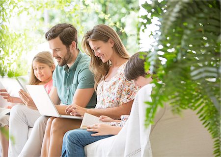 Family reading and using technology on patio Photographie de stock - Premium Libres de Droits, Code: 6113-07242020