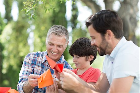 dad teaching - Multi-generation men making origami outdoors Foto de stock - Sin royalties Premium, Código: 6113-07242035