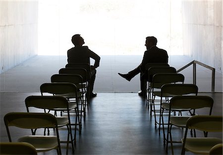 Businessmen talking at chairs in a row Stock Photo - Premium Royalty-Free, Code: 6113-07242140
