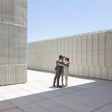 successful businessman standing photo - Business people hugging outdoors Stock Photo - Premium Royalty-Free, Code: 6113-07242173